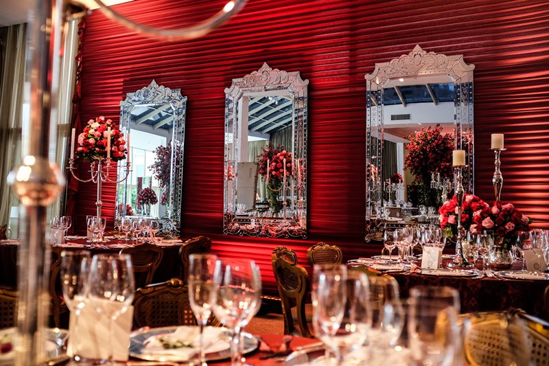 A parede ornamentada com espelhos venezianos ficou ainda mais charmosa sobre o painel em vermelho - Foto Anderson Miranda